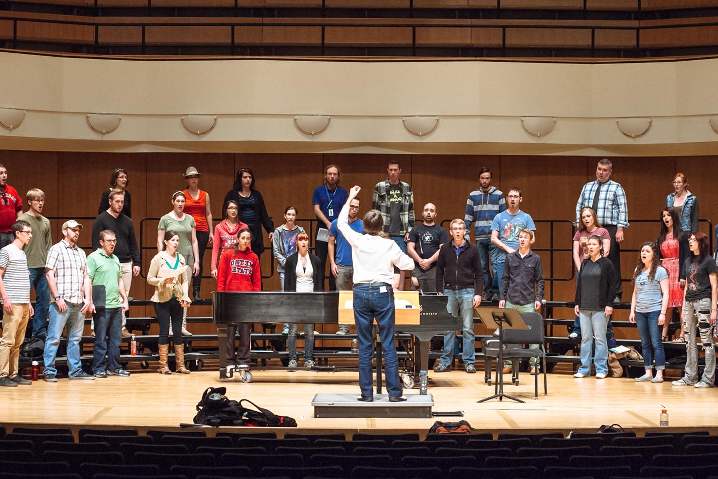 Choral conductor leading a choir rehearsal in the King Center Concert Hall