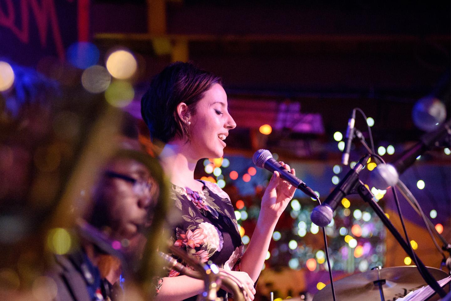 Jazz singer performing on stage with twinkling lights