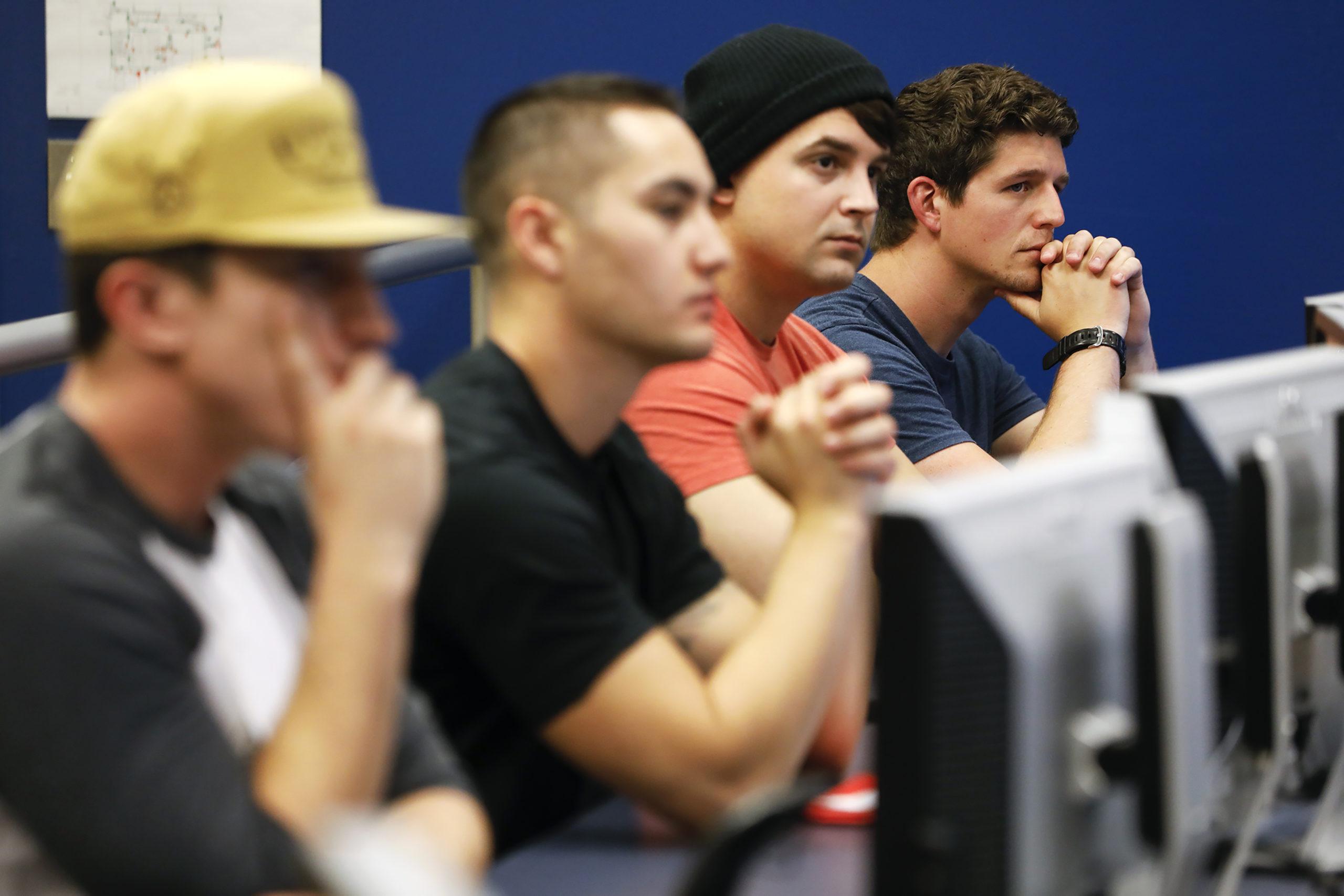 MSU Denver students sitting in front of computer monitors and listening intently.